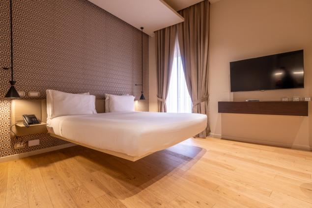 Modern room with floating bed and wall-mounted TV.